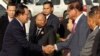 Prime Minister Hun Sen, left, shakes hands with Deputy Prime Minister Minister of the Interior Sar Kheng as they arrive to attend a ceremony for the 68th anniversary of the founding of the Cambodian People's Party, in Phnom Penh, Cambodia, Friday, June 28, 2019. (AP Photo)