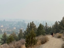 A runner descends a trail on Pilot Butte, a lava dome overlooking the city of Bend, Ore., Sept. 15, 2020. Wildfires have created hazardous air quality in Bend and other cities across the U.S. West.