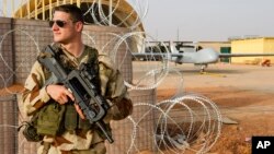 FILE - A French air force soldier on guard near a Hartford drone, at the Niamey military base, in Niger.