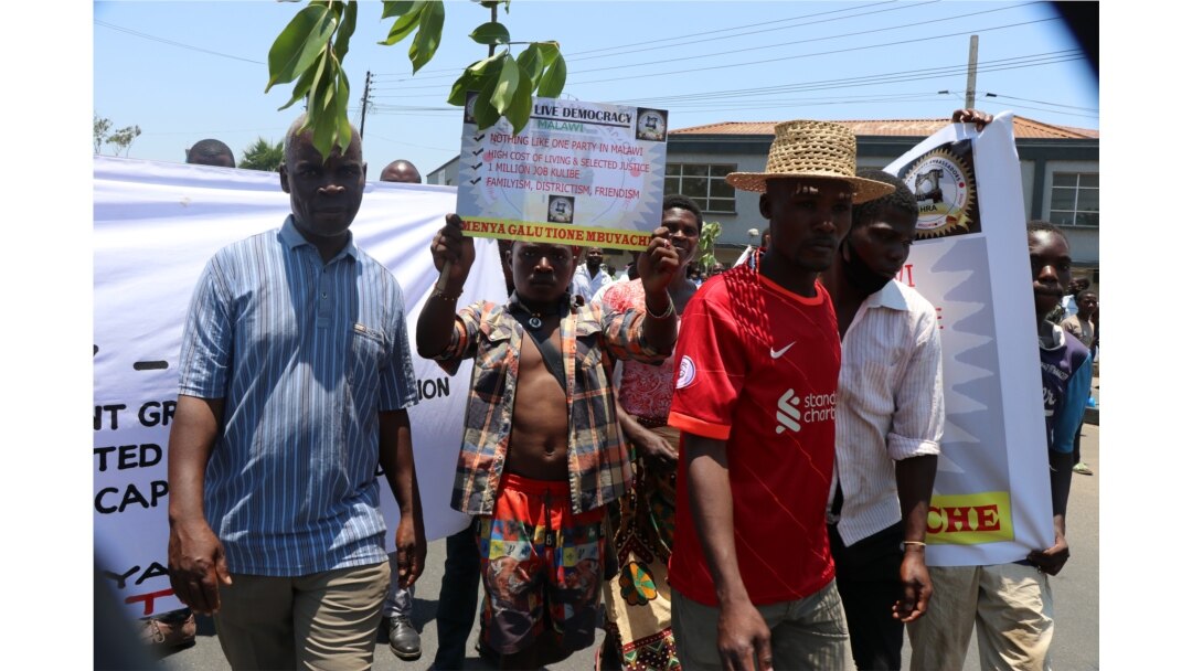 A protestor carrying carrying a placard during Tuesday protests in Blantyre. (Lameck Masina/VOA)
