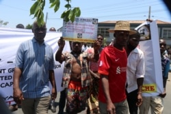 A protestor carrying carrying a placard during Tuesday protests in Blantyre. (Lameck Masina/VOA)