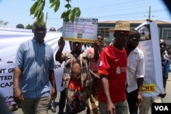 A protestor carrying carrying a placard during Tuesday protests in Blantyre. (Lameck Masina/VOA)