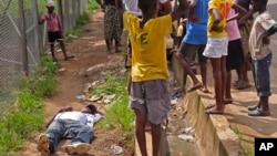 Deca okupljena oko čoveka koji je pao na ulici, a za koga se sumnja da je inficiran virusom ebole, Liberija, 19. avgust 2014.