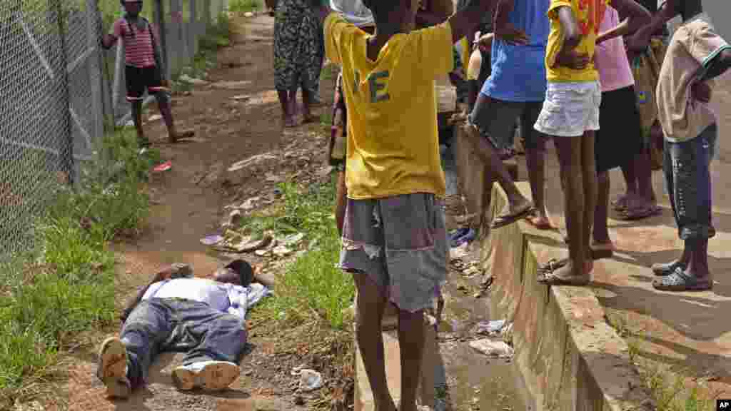 Children surround a man suspected of having contracted the Ebola virus,&nbsp;Monrovia, August 19, 2014.