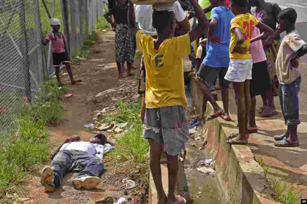 A Monrovia, les enfants entourent un homme tombé en marchant, suspecté d&#39;avoir contracté le virus Ebola.