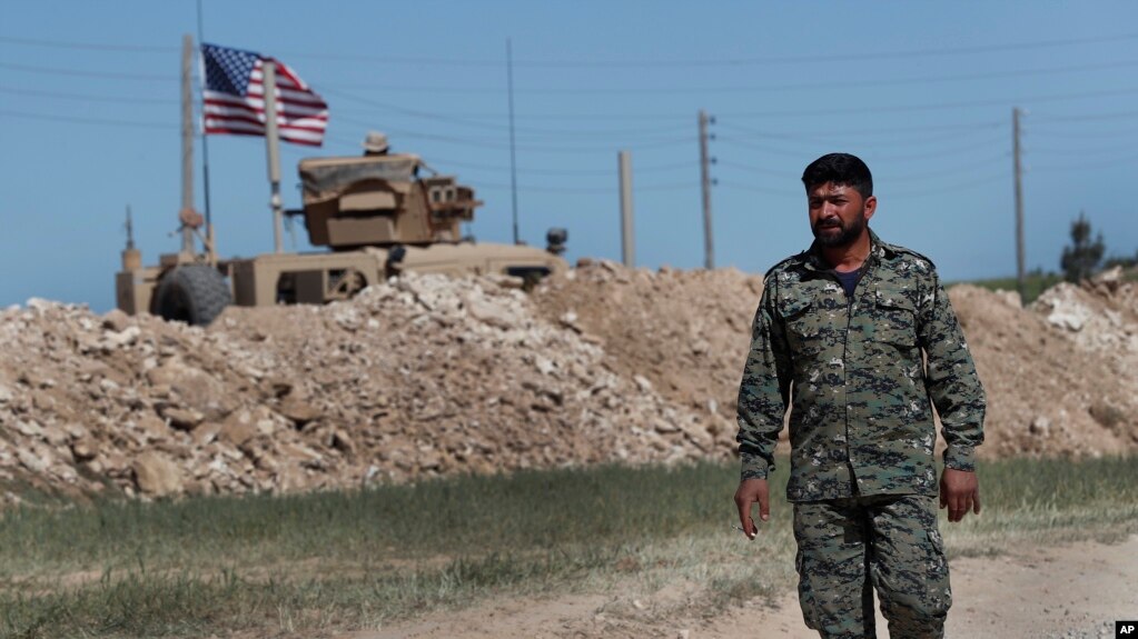 En esta foto de archvio se ve a un solado sirio del Concejo Militar Manbij, respaldado por EE.UU. frente a una posiciÃ³n de EE.UU. en Manbij, norte de Siria, el 4 de abril de 2018.
