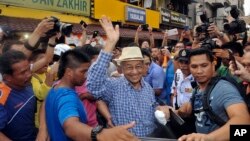 Mantan PM Malaysia, Mahathir Mohamad (bertopi) ikut hadir pada acara unjuk rasa menuntut pengunduran diri PM Najib Razak ​di Kuala Lumpur, Minggu (30/8).