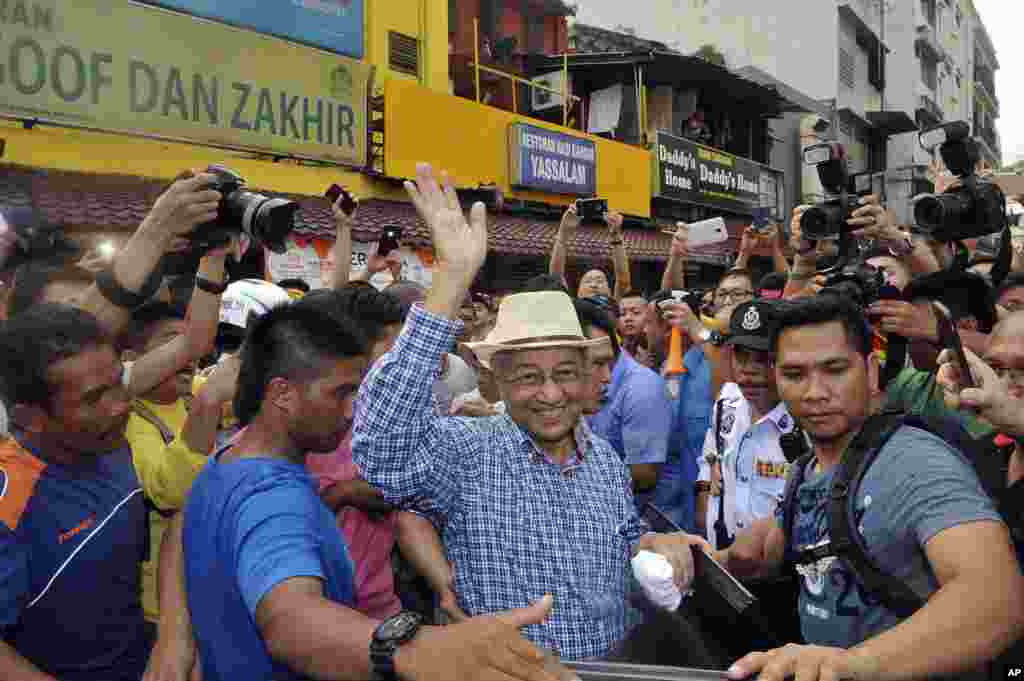 Mantan Perdana Menteri Malaysia, Mahathir Mohamad (tengah) melambaikan tangan kepada para aktivis Koalisi Pemilu Bersih dan Adil (BERSIH) saat tiba di tengah demonstrasi di Kuala Lumpur (30/8).