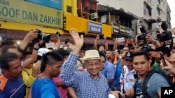 Mantan Perdana Menteri Malaysia Mahathir Mohamad, tengah, melambaikan tangan ke arah aktivis dari Coalition for Clean and Fair Elections (BERSIH) ketika tiba di demo di Kuala Lumpur, Malaysia, 30 Agustus 2015. 