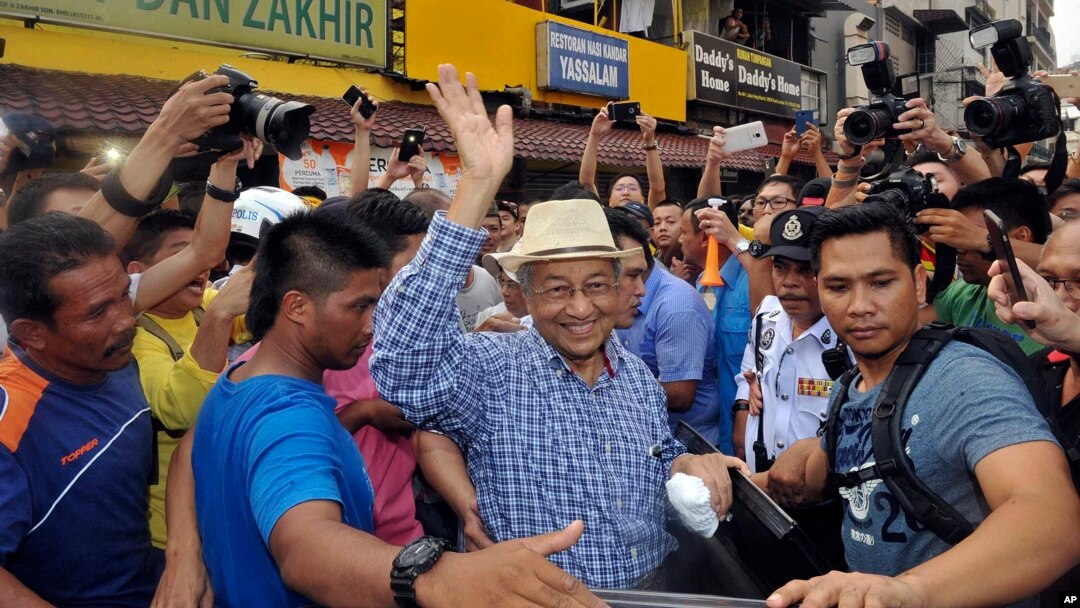 Mantan PM Malaysia, Mahathir Mohamad (bertopi) ikut hadir pada acara unjuk rasa menuntut pengunduran diri PM Najib Razak ​di Kuala Lumpur, Minggu (30/8).