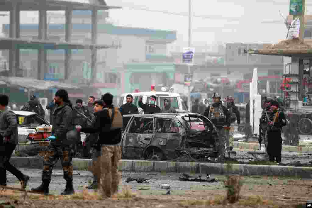 Afghan security personnel inspect the site of a bombing attack in Kabul.