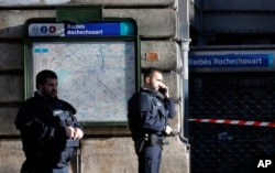 Police officers secure the area after a fatal shooting which took place at a police station in Paris, Jan. 7, 2016.