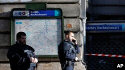 Des policiers patrouillent dans la zone où a eu lieu une fusillade mortelle à Paris, France, 7 janvier 2016. (AP Photo / Christophe Ena)