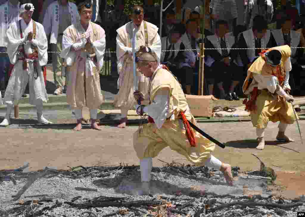 راهب بودایی در شهر توکیوی جاپان در مراسم سنتی پای برهنه از روی آتش می گذرد