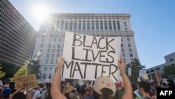 Supporters of Black Lives Matter, hold signs during a protest outside the Hall of Justice as they demonstrate against the death of George Floyd, in Los Angeles, California on June 10, 2020. (Photo by Mark RALSTON / AFP)