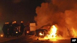 Egyptian firemen try to put out a fire on a vehicle following a car bombing in front of a Coptic Christian church in the Egyptian city of Alexandria, 01 Jan 2011