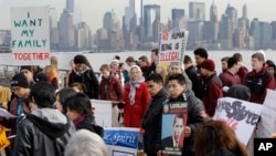 Defensores de la reforma migratoria toman parte en un mitin en Ellis Island, cerca de la Estatua de la Libertad, en Nueva York.