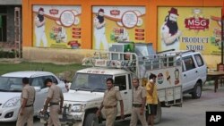 Sekelompok polisi India berjalan di depan toko milik pemimpin sekte Dera Sacha Sauda, Gurmeet Ram Rahim Singh setelah disegel oleh pihak berwenang di Sonipat, India, 26 Agustus 2017. 