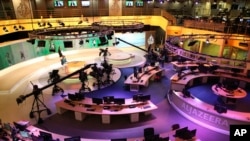 FILE - Staff members of Al-Jazeera International work at the news studio in Doha, Qatar, Jan. 1, 2015. Kuwait has given Qatar a list of demands from Saudi Arabia and other Arab nations that includes shutting down Al-Jazeera and cutting diplomatic ties to Iran.