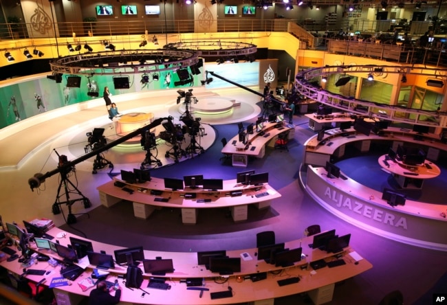 FILE - Staff members of Al-Jazeera International work at the news studio in Doha, Qatar, Jan. 1, 2015.