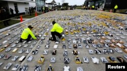 Colombian anti-narcotics policemen inspect packs of cocaine at the police base in Necocli, Feb. 24, 2015. 