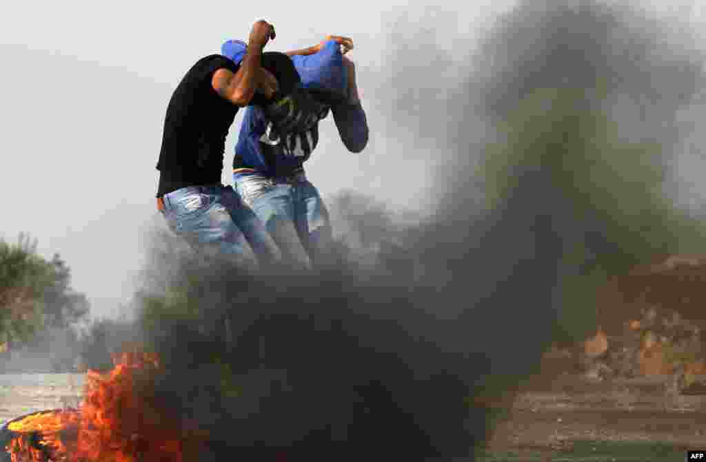 Birzeit University students cover their faces during clashes with Israeli soldier in Gaza, Nov 19, 2012.