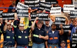 FILE - A group of coal miners wave Trump signs as they wait for a rally in Charleston, W.Va., May 5, 2016.