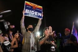 FILE - A supporter of U.S. President Donald Trump defends the right of a presidential nominee Joe Biden supporter to be at a gathering during a protest about the early results of the 2020 U.S. presidential election, in Phoenix, Arizona, Nov. 6, 2020.