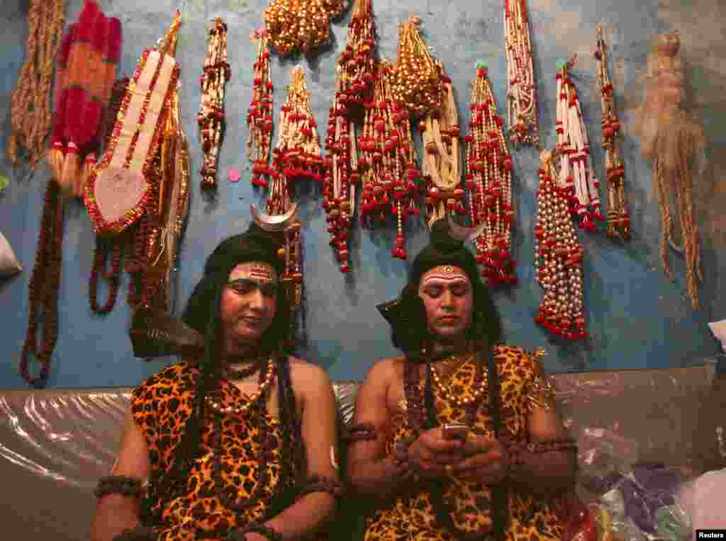 Artists dressed as the Hindu Lord Shiva read a message on a mobile phone as they prepare to participate in a religious procession ahead of the Mahashivratri festival in Jammu, Nepal. Hindu women across the country celebrate Mahashivratri, better known as Lord Shiva&#39;s wedding anniversary, so that their husbands will be blessed with long lives.