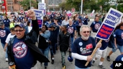 Members and family of unions walk in the annual Labor Day parade in Detroit, Monday, Sept. 5, 2011. (AP Photo/Paul Sancya)