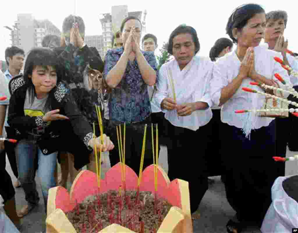 Cambodian women offer prayer during a memorial service Thursday, Nov. 25, 2010, near a bridge where hundreds of festival goers were killed Monday in a stampede in Phnom Penh, Cambodia. Cambodia began a day of mourning Thursday with the prime minister weep