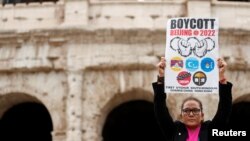 FILE - A demonstrator holds a placard as activists demonstrate outside the Colosseum, calling on G-20 leaders to boycott the Beijing 2022 Winter Olympics due to China's treatment of Tibet, Uyghur Muslims and Hong Kong, in Rome, Italy, Oct. 29, 2021. 