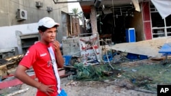 一名男子在視察巴格達一個居民區在汽車炸彈爆炸後的情況