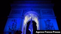 People gather at the Arc de Triomphe lit up in blue to mark the French presidency of the European in Paris, Jan. 1, 2022. 