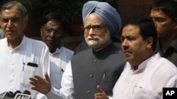 Indian Prime Minister Manmohan Singh, center, talks to the media in New Delhi, Aug. 8, 2012. 