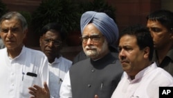 Indian Prime Minister Manmohan Singh, center, talks to the media in New Delhi, August 8, 2012. 