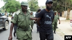 Un policier arrête le musicien zambien Chama Fumba, connu sous le nom de Pilato, lors d'une marche vers le bâtiment du parlement à Lusaka le 29 septembre 2017.