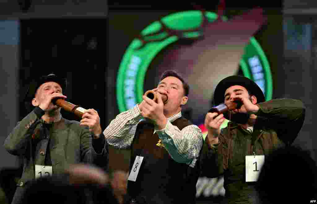 Second-place Thomas Soltwedel, left, winner Fabian Menzel and third-place Jerome Boehm, right, perform after the German Deer Calling Championship on the sidelines of the Jagd &amp; Hund (Hunting and Dog) trade fair in Dortmund, Germany.