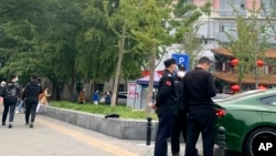 FILE - Police officers stand near a bridge where social media videos earlier appeared to show smoke and protest banners in Beijing, Oct. 13, 2022. 