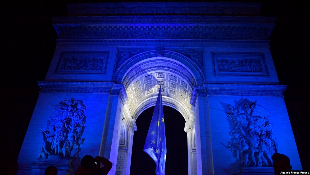 People gather at the Arc de Triomphe lit up in blue to mark the French presidency of the European in Paris, Jan. 1, 2022. 
