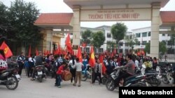 Hàng trăm học sinh tiểu học, trung học cơ sở tập trung trước cổng trường Ninh Hiệp phản đối việc xây trung tâm thương mại. (ảnh chụp từ trang thanhnien).