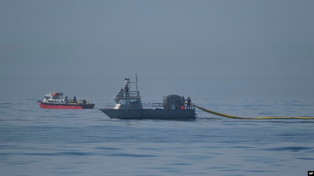 抢救船只正在海面上放置被称为围油栏的浮动屏障。(photo:VOA)