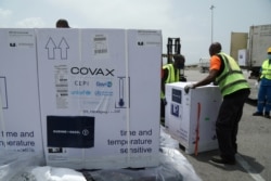 FILE - Workers offload boxes of COVID-19 vaccines distributed to lower-income countries under the COVAX initiative, in Abidjan, Ivory Coast, Feb. 26, 2021.