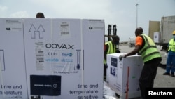 FILE - Workers offload boxes of COVID-19 vaccines distrubuted to lower-income countries under the COVAX initiative, in Abidjan, Ivory Coast, Feb. 26, 2021. 