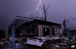 FILE - Lightning illuminates a house after a tornado touched down in Jefferson County, Ala., damaging several houses, Friday, Dec. 25, 2015.
