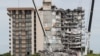 Petugas darurat melakukan upaya pencarian dan penyelamatan di lokasi bangunan tempat tinggal yang sebagian runtuh di Surfside, dekat Miami Beach, Florida, AS, 29 Juni 2021. (Foto: REUTERS/Joe Skipper)