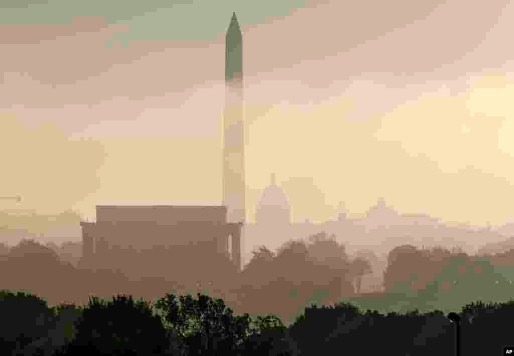 The famous monuments of Washington seen through the fog over the U.S. capitol. The photo was taken from an overlook in Arlington, Virginia. From left to right: the Lincoln Memorial, Washington Monument, the Capitol, the Smithsonian Castle, and the Library of Congress. 