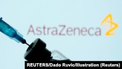 FILE PHOTO: A vial and sryinge are seen in front of a displayed AstraZeneca logo