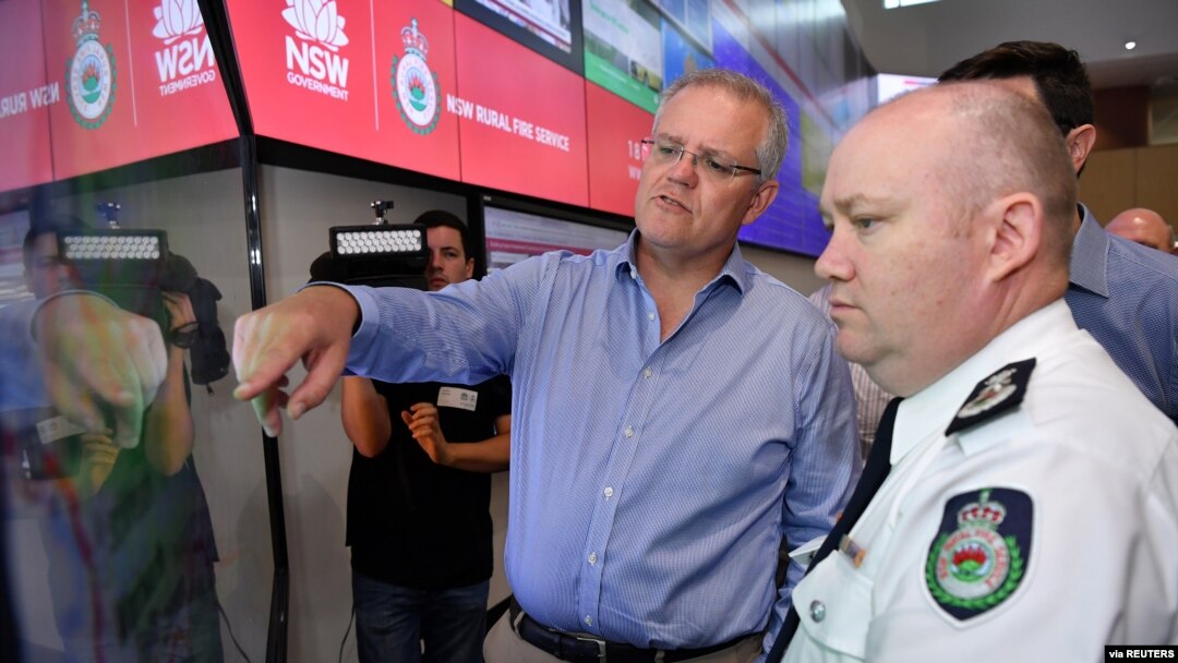 Perdana Menteri Australia Scott Morrison mendapat penjelasan dari Komisioner Dinas Pemadam Kebakaran New South Wales Shane Fitzsimmons di ruang kontrol Dinas Pemadam Kebakaran NSW, 22 Desember 2019. 