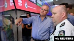 Perdana Menteri Australia Scott Morrison mendapat penjelasan dari Komisioner Dinas Pemadam Kebakaran New South Wales Shane Fitzsimmons di ruang kontrol Dinas Pemadam Kebakaran NSW, 22 Desember 2019. 